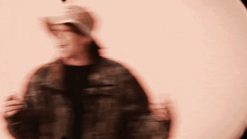 a blurry picture of a person wearing a hat and a jacket