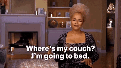 a woman is sitting in a living room talking about where 's her couch ? i 'm going to bed