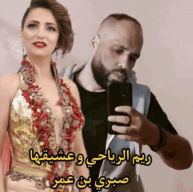 a man is taking a selfie next to a woman with arabic writing on it