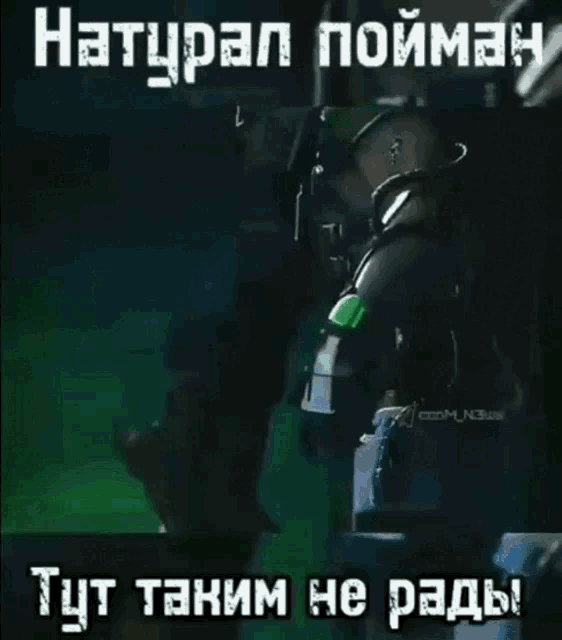 a video of a man kneeling down in a dark room with russian writing
