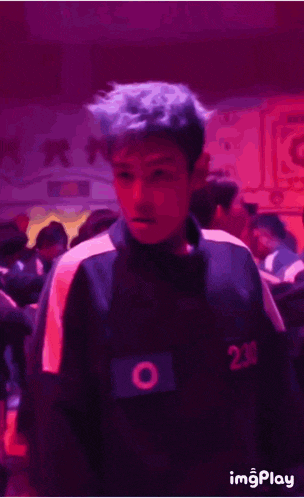 a man with blue hair is wearing a number 230 shirt