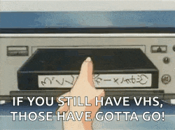 a person is pointing at a vhs tape in a machine .