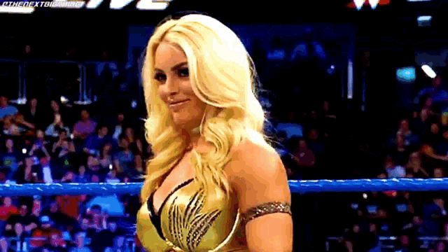 a female wrestler is standing in a ring with a crowd behind her and a watermark that says thenextbigthing