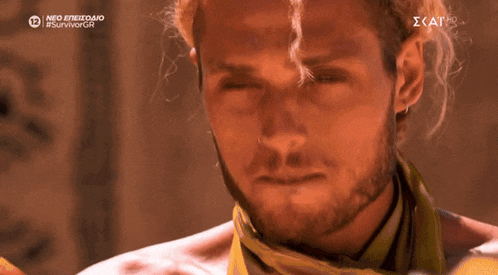 a man with a beard and a yellow scarf around his neck is on a screen that says neo epiezio #survivorgr