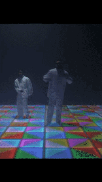 two men dancing on a colorful dance floor
