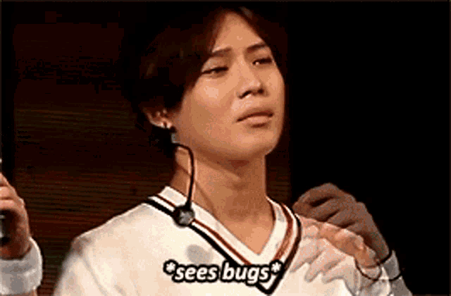 a man wearing a white shirt with a microphone around his neck says sees bugs .