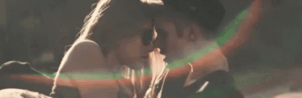 a man and a woman are kissing each other on a bed .