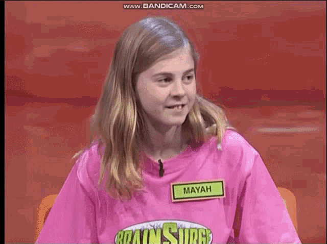a young girl is wearing a pink shirt with a name tag that says mayah