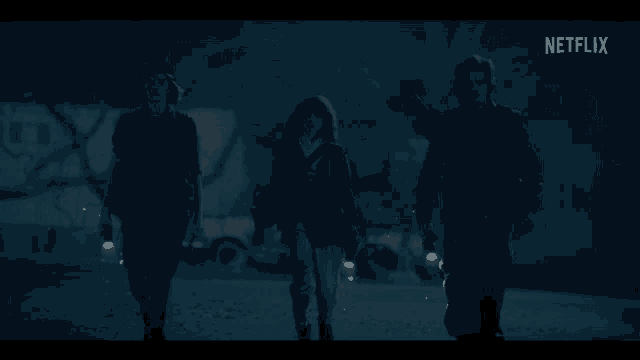 a group of people walking in the dark with a netflix logo behind them