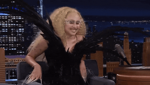 a woman with blonde hair is wearing a black dress