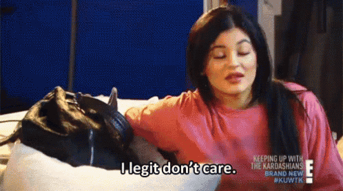 a woman is sitting on a couch holding a purse and saying i legit don t care .