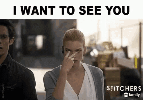 a man and a woman are standing next to each other and the woman is pointing at the man 's face .