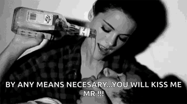 a woman is pouring a bottle of alcohol into a man 's face .