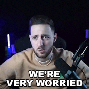 a man is sitting in front of a microphone with the words `` we 're very worried '' written on his face .