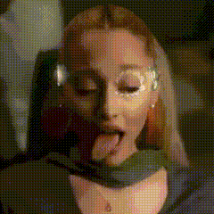 a woman is sticking her tongue out while wearing headphones .