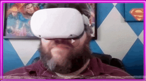 a man with a beard is wearing a virtual reality headset in a room .