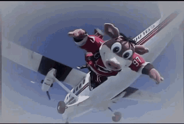 a stuffed animal is jumping out of a plane with the number 76 on his shirt
