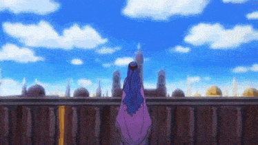 a woman is standing on a balcony overlooking a city .