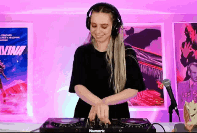 a woman wearing headphones is playing music on a numark dj mixer
