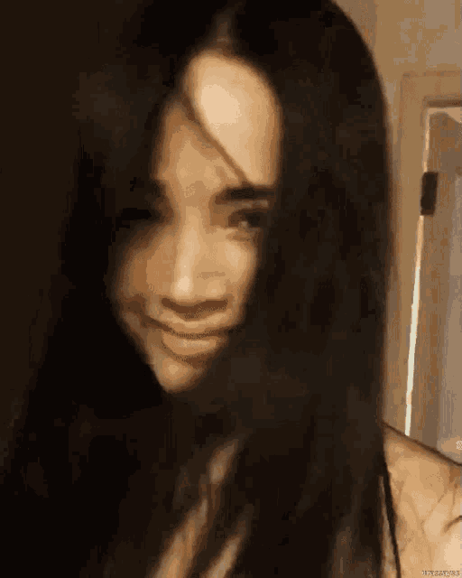 a close up of a woman 's face with her hair covering half of it