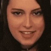 a close up of a woman 's face with a choker smiling .