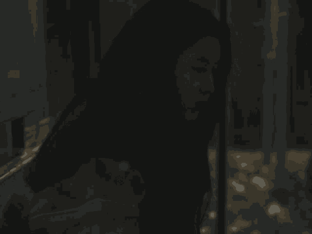 a woman with long dark hair is standing in the dark