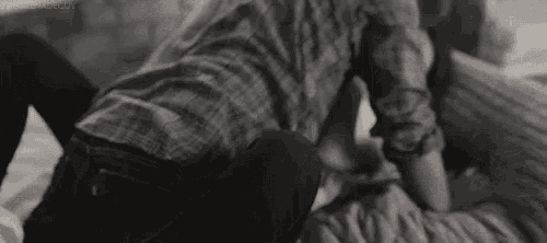 a man and a woman are laying on a bed .