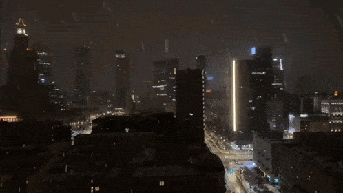 a cityscape at night with a tall building that says ' allianz ' on it