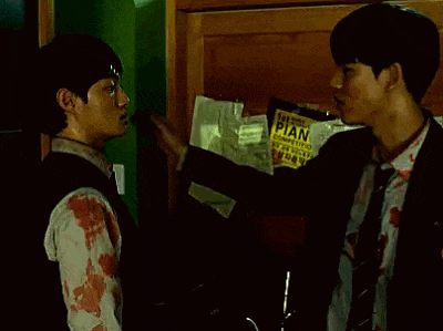 two men are standing next to each other in a dark room .