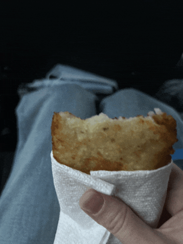 a person is holding a piece of food on a napkin