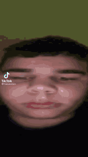a close up of a man 's face with a tik tok sticker on it .