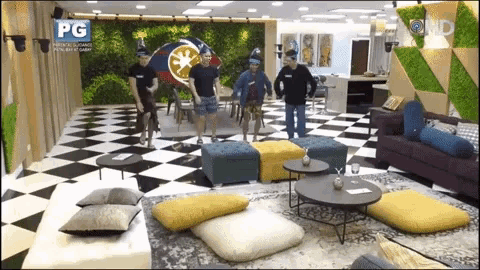 a group of men are dancing in a living room with a pg logo on the bottom right