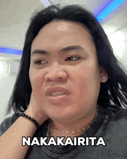 a man with long hair is making a funny face and the word nakaarita is on the bottom of his shirt