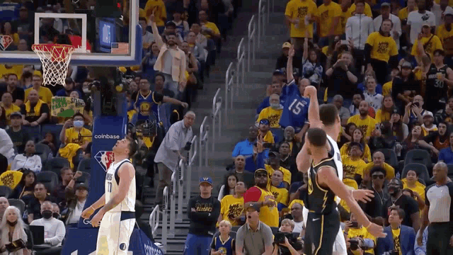 a basketball game is being played in front of a crowd with a coinbase banner in the background