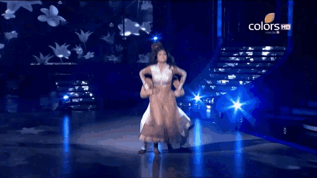 a man and a woman are dancing on a stage with the words colors hd on the bottom right