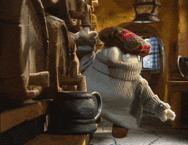 a stuffed animal wearing a sweater and a hat is standing in a room