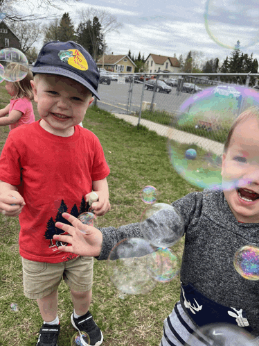 a boy wearing a hat that says bass pro shops is blowing soap bubbles