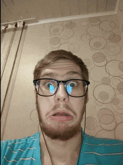a man with a beard wearing glasses and headphones makes a funny face