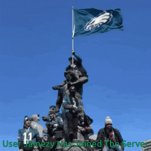 a group of people standing around a statue holding a flag that says eagles