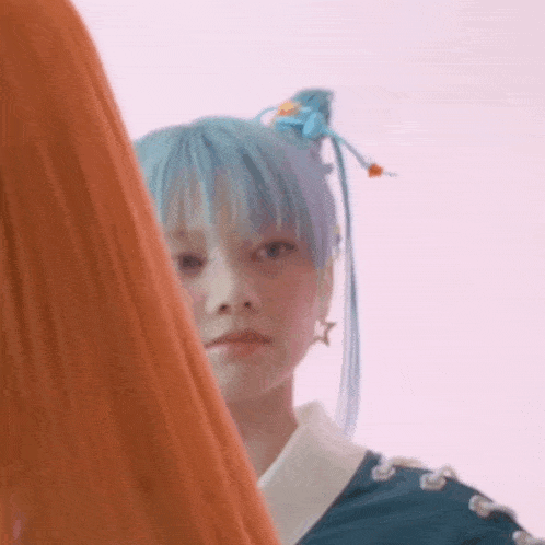 a close up of a girl with blue hair looking at the camera .