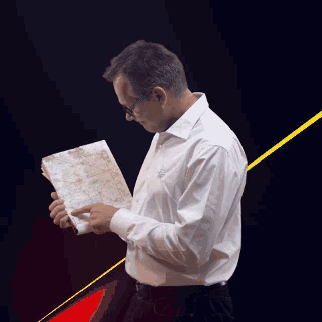 a man in a white shirt is holding a map in his hand