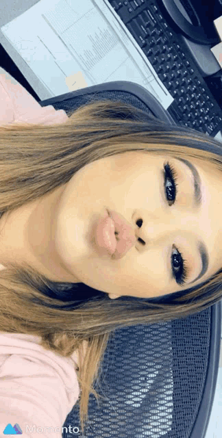 a woman is making a funny face in front of a keyboard with the word momento on the bottom