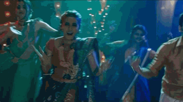 a group of people are dancing in a dark room in a club .