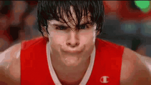 a basketball player is making a funny face while sweating .