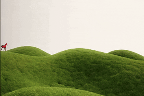 a red horse on top of a green hill