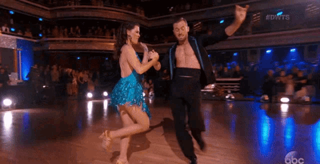 a man and a woman are dancing on a dance floor