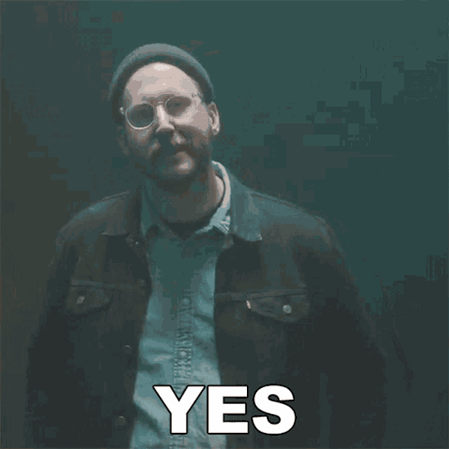 a man with a beard wearing glasses and a beanie says yes