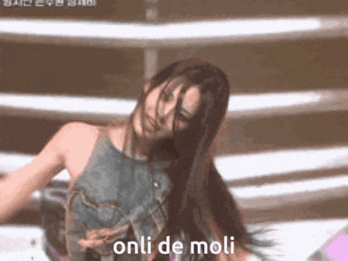 a woman with long hair is dancing and the words onli de moli are visible