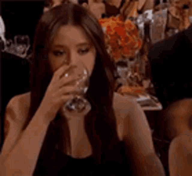 a woman is holding a glass of wine in her hand .