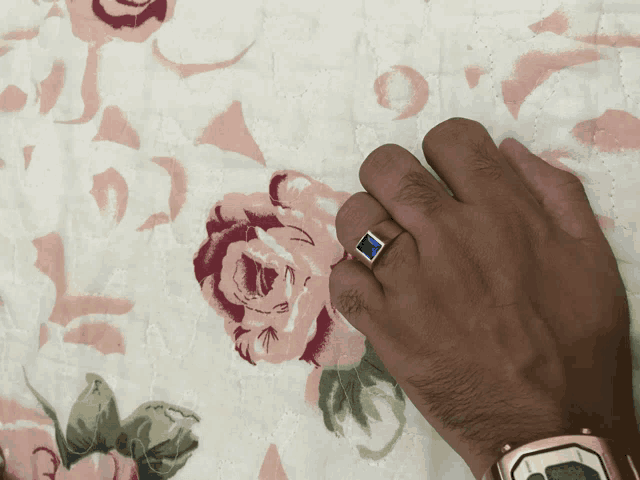 a man wearing a gold watch and a blue ring on his finger